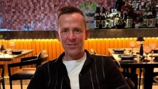 Scott Mills está sentado num restaurante