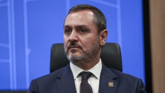 Andrei Rodrigues olha para o lado, à frente de um fundo azul