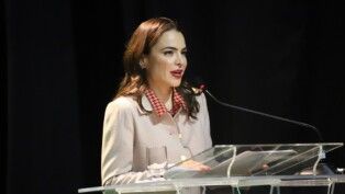 Delegada fala ao microfone durante cerimônia