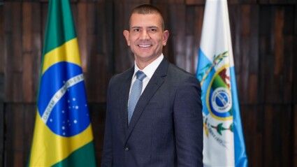 Douglas Ruas aparece à frente das bandeiras do Brasil e do Rio.