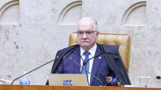 Edson Fachin está sentado na cadeira da presidência do STF durante sessão plenária