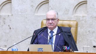 Edson Fachin está sentado na cadeira da presidência do STF durante sessão plenária
