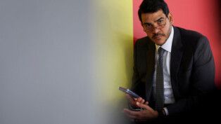 Jorge Messias segura o telefone celular