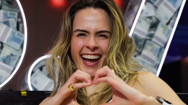 Ana Paula sorri e faz gesto de coração com a mão.