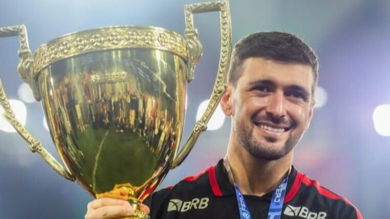 Arrascaeta com uniforme do Flamengo e taça.