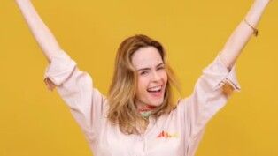 Ana Paula com macacão rosa e sorrindo.