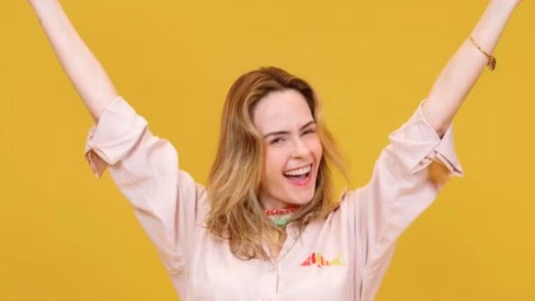 Ana Paula com macacão rosa e sorrindo.