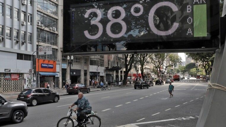 Pessoas na rua durante forte onda de calor.