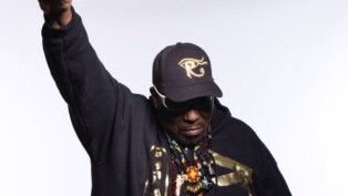 Afrika Bambaataa com o punho levantado.