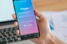 Uma pessoa segurando um celular que está na tela do Instagram.