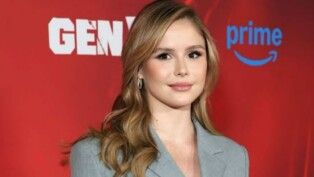 Atriz de The Boys usando um terno cinza.