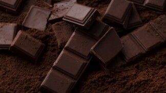 Barras de chocolate em meio ao cacau em pó.