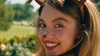 Mulher loira vestida de cachorro dando um sorriso para a câmera.