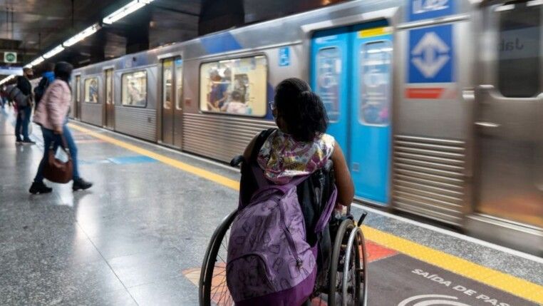 Pessoas esperando metrô na plataforma.