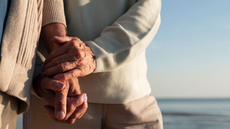 Casal de idosos de mãos dadas.