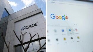 No lado esquerdo da foto há um prédio cinza e do lado direito há uma tela de computador.