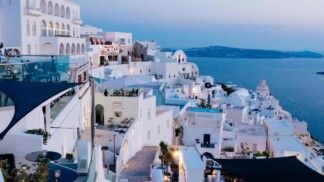 Céu azul com diversas casas e pequenos apartamentos brancos.