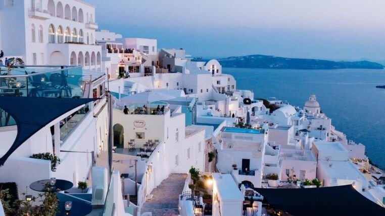 Céu azul com diversas casas e pequenos apartamentos brancos.