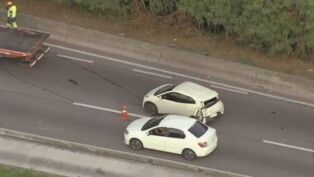 Dois carros parados no meio de uma rodovia, vistos de cima