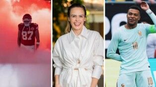Na foto ao lado direito está o jogador Kylian Mbappé com uniforme verde, ao centro está a Ana Paula de camisa branca e no lado esquerdo está Travis Kelce.
