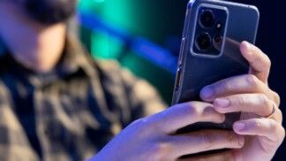 Homem segurando celular.