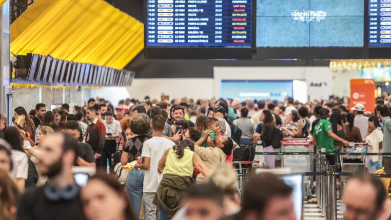 Pessoas circulando pelo saguão de um aeroporto