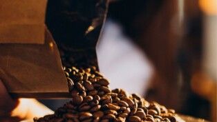 Grãos de café caindo em um recipiente.