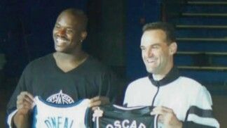 Dois homens seguram uniformes de times de basquete.