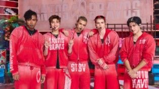 Há 5 homens na foto, todos estão de roupa vermelha com escritos em branco.