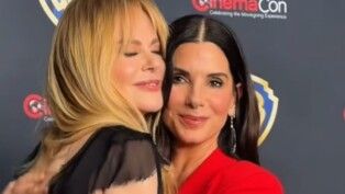 Duas mulheres se abraçam, uma é loira e outra morena.