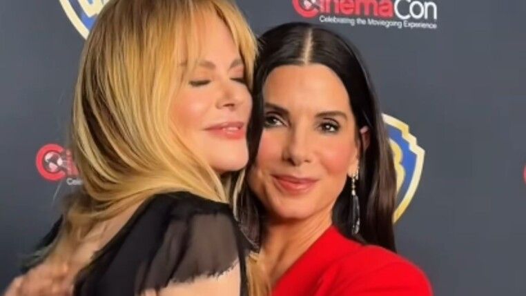 Duas mulheres se abraçam, uma é loira e outra morena.