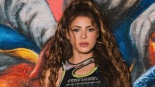 Shakira com cabelo preso e cacheado.