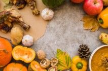 Há diversos alimentos com folhas de árvores em uma mesa.