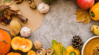 Há diversos alimentos com folhas de árvores em uma mesa.