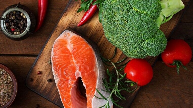 Na foto há um filé de peixe e um brócolis.