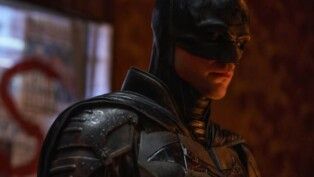 Homem fantasiado com máscara e capa.