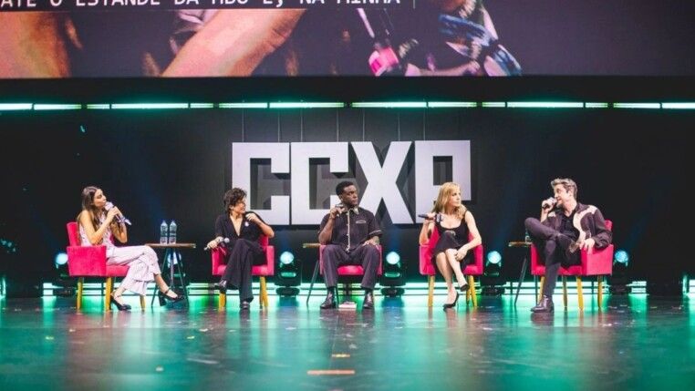 Na foto estão cinco pessoas, elas estão em um palco.