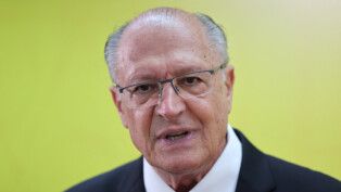 Geraldo Alckmin fala à frente de um fundo amarelo