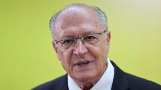 Geraldo Alckmin fala à frente de um fundo amarelo