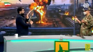 A presenter from Iran State TV and live firearms trainer speak in a studio where the presenter fired a gun at a UAE flag, in Tehran, MAY 15, 2026. Pool via WANA (West Asia News Agency)/ via REUTERS ATTENTION EDITORS - THIS PICTURE WAS PROVIDED BY A THIRD PARTY. IRAN OUT. NO COMMERCIAL OR EDITORIAL SALES IN IRAN. NO USE BBC PERSIAN. NO USE VOA PERSIAN. NO USE MANOTO. NO USE IRAN INTERNATIONAL. NO USE RADIO FARDA.