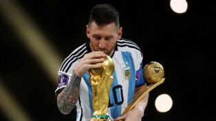 Messi segura um troféu com uma mãe e beija a taça da Copa do Mundo
