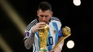 Messi segura um troféu com uma mãe e beija a taça da Copa do Mundo