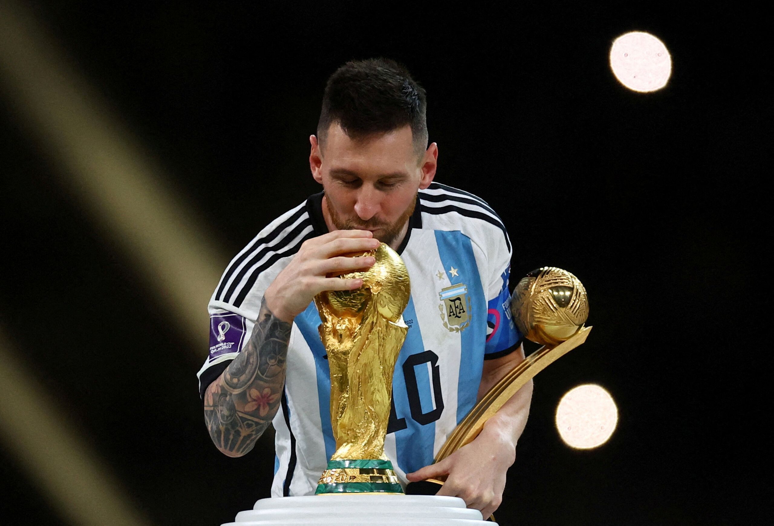 Messi segura um troféu com uma mãe e beija a taça da Copa do Mundo
