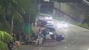 Porsche batido e carros da polícia na rua à noite