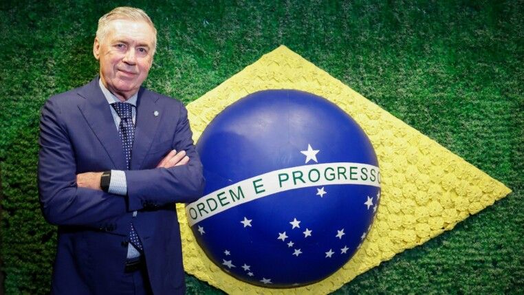 Ancelotti está de braços curados à frente da bandeira do Brasil