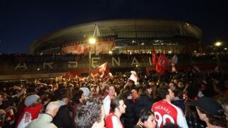Torcedores do Arsenal FC comemoram do lado de fora do estádio Emirates após a conquista da Premier League pelo clube