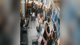 Mulher levanta a mão com uma faca atrás de cabeleireiro durante seu trabalho