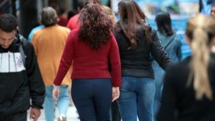 Pessoas agasalhadas com casacos na rua em São Paulo.