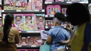 Mulheres observam brinquedos em prateleiras
