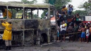 Peritos retiram corpos dos sete passageiros que morreram carbonizados no ataque feito por traficantes supostamente ligados ao Comando Vermelho, ao ônibus da Viação Itapemirim, na Avenida Brasil, no Rio de Janeiro durante a madrugada